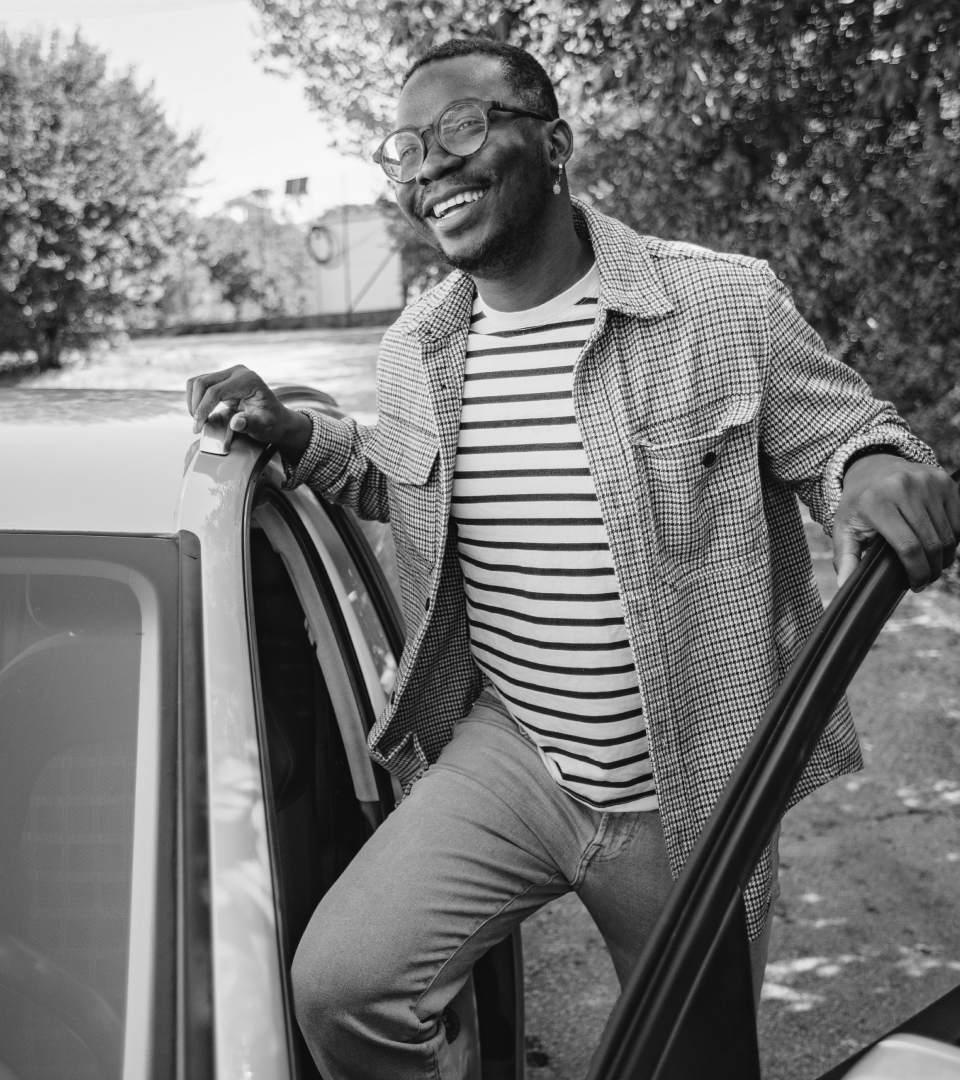 Man smiling getting into his car.