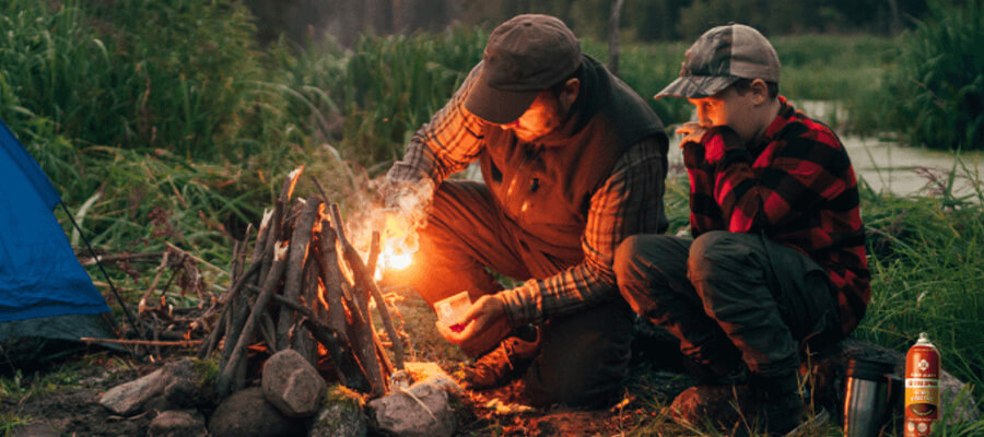 A father and son build a campfire.