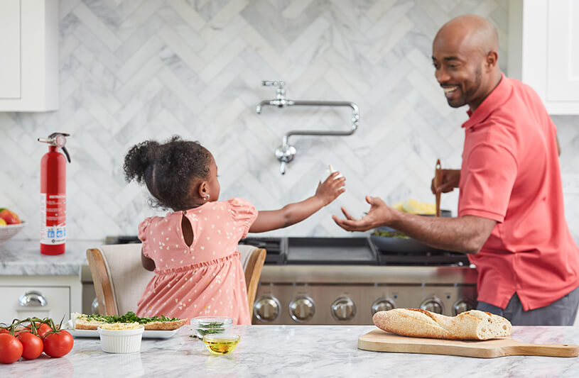 Father and daughter cooking in the kitchen.