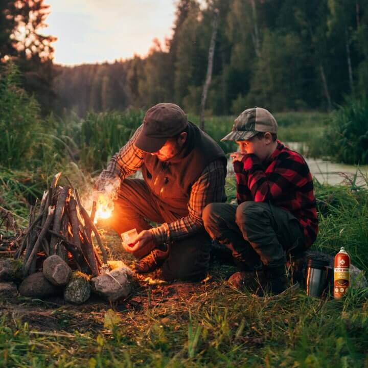 father and son starting campfire