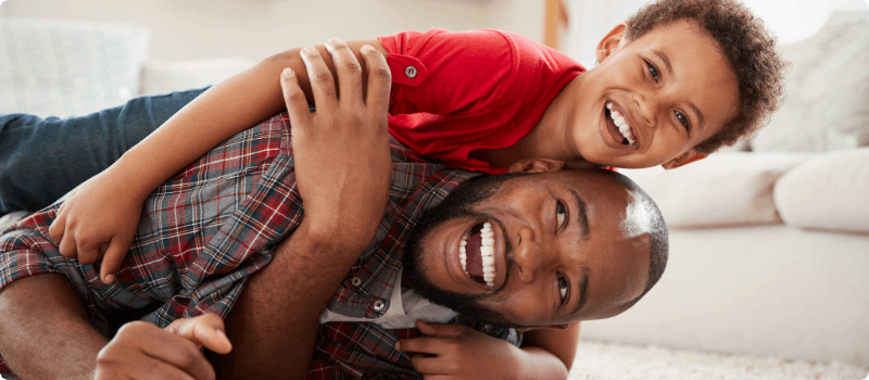 Father and son smiling in living room
