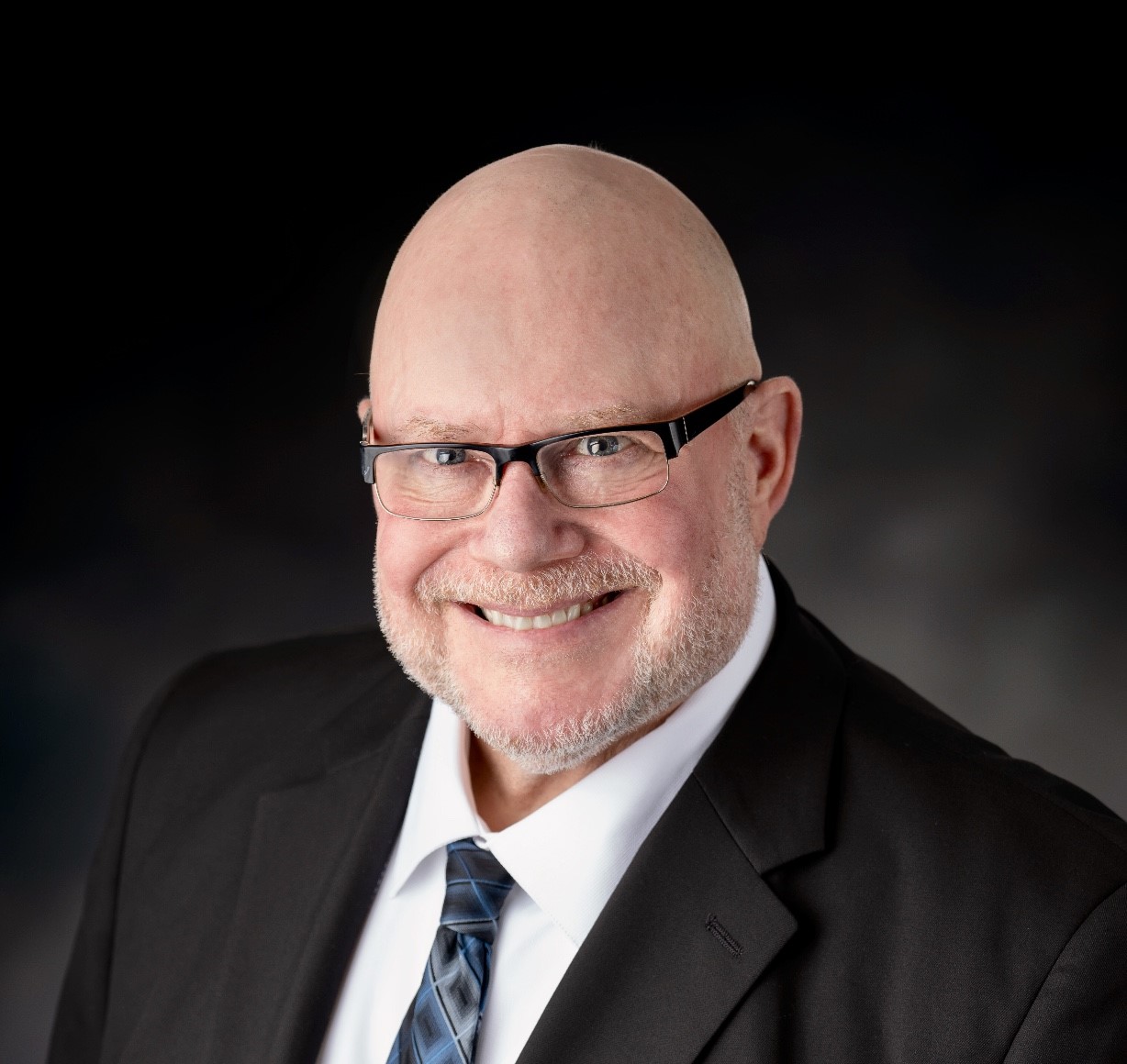 a man wearing glasses and a suit