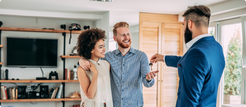 couple getting keys to their new home from realtor