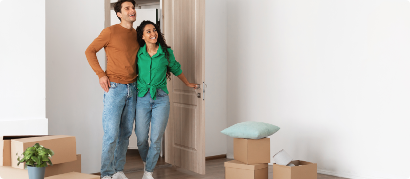 man and woman walking into new home