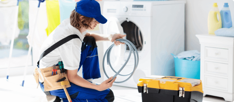 A worker fixing a home dryer.