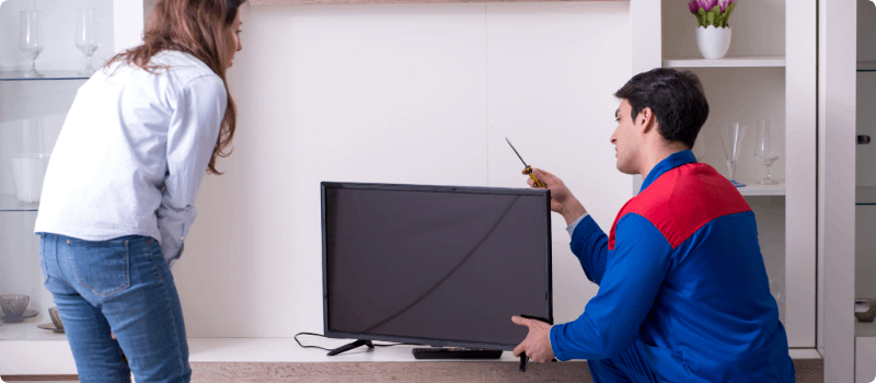 A worker fixing a home television. 