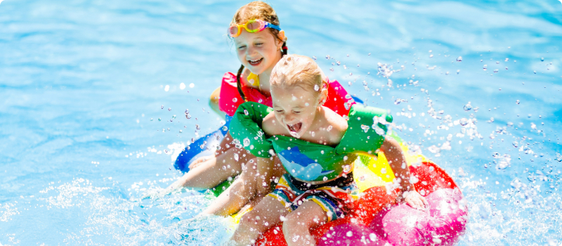 Two kids playing in their pool.