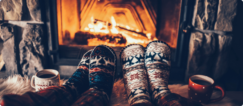 Couple's feet in front of a cozy fire. 