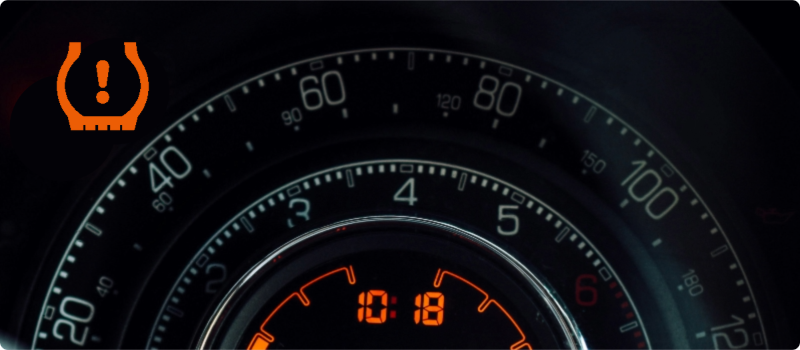 A tire pressure warning light illuminated on a car's dashboard.