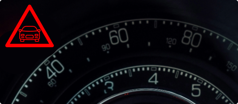 A close-up of a car's dashboard with the distance warning light illuminated. 
