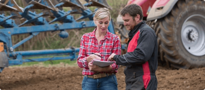 Farmer reviewing documents with an insurance agent. 