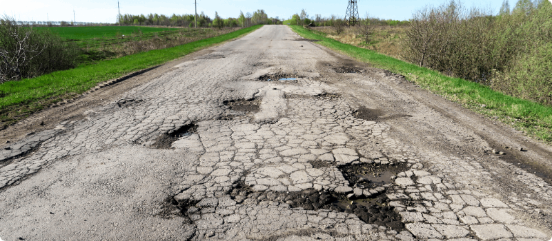 Damaged road with potholes.