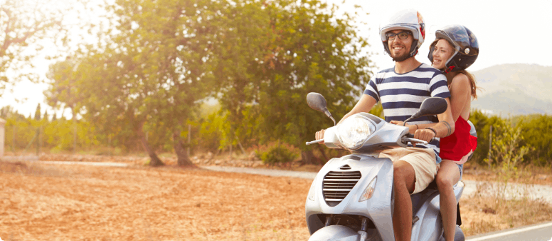 Two people going for a scooter drive on a sunny day.