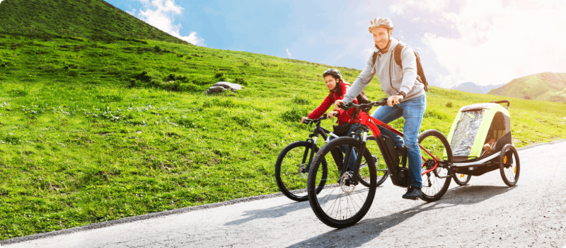 A small family going for an e-bike ride on a sunny day.