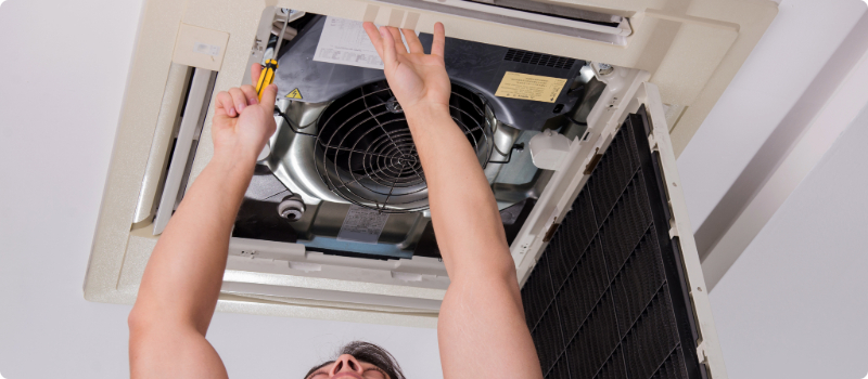 A worker fixing a home air conditioning system.