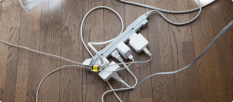 A power strip overloaded with plugs.