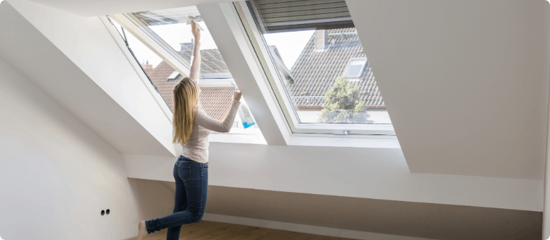 Person opening skylights in her home.