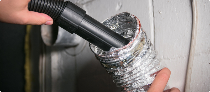 A close-up of a person cleaning their dryer vents.