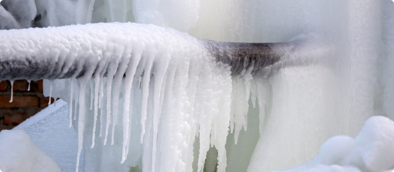 A close-up of a home's pipe covered in ice.