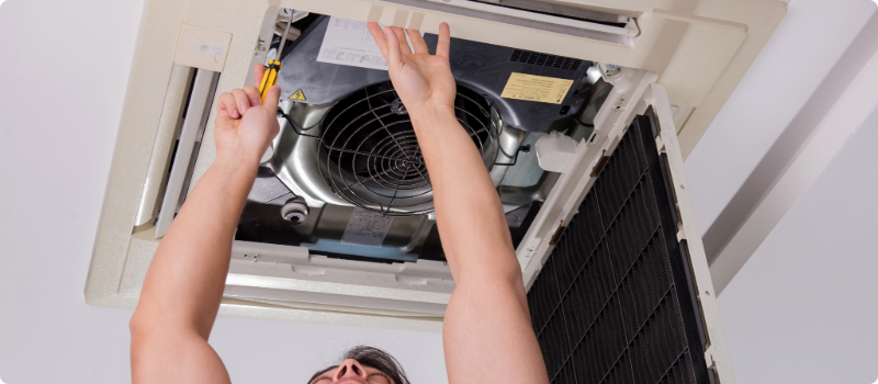 A worker fixing a home's air conditioning unit.