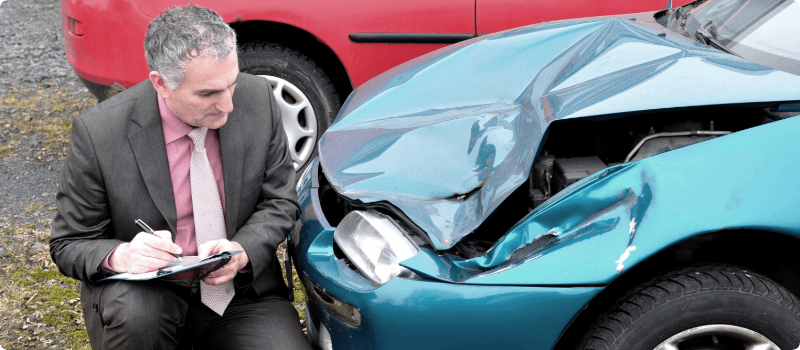 Auto claims adjuster assessing auto damages. 