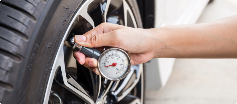 A person checking their tire pressure.