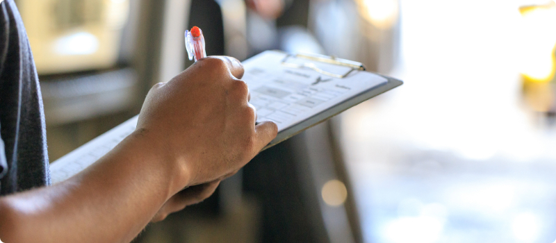 A person writing on a clipboard.