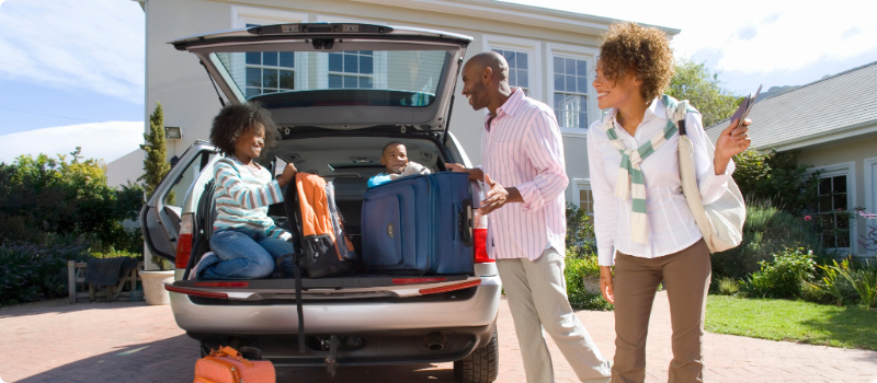 A happy family packing their SUV for a trip.