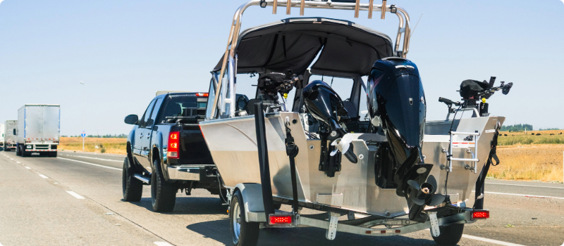 A truck towing a boat. 