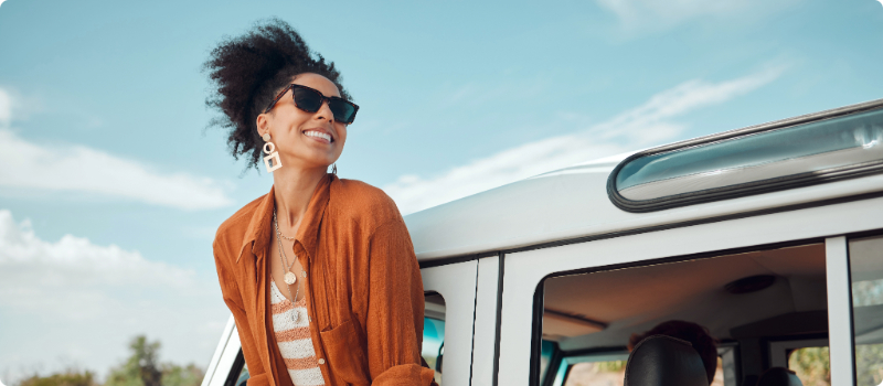 A happy person leaning out their SUV window.