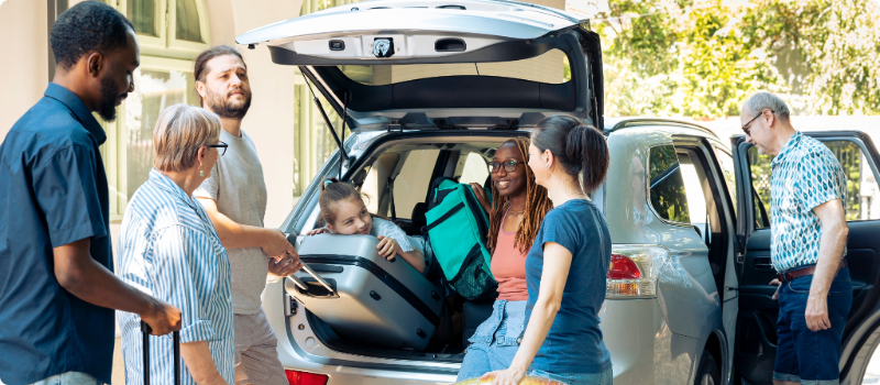 A happy family packing their car for a road trip.