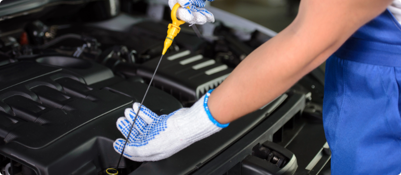 A mechanic checking a car's oil.