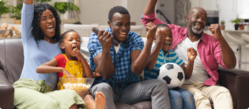 A large, happy family celebrating on their couch.