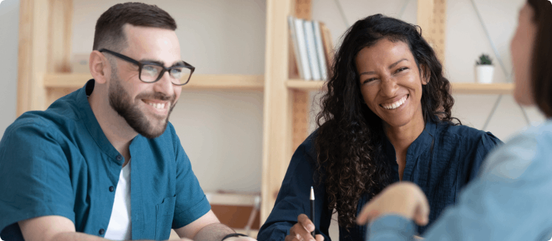 Happy couple speaking with an insurance agent.