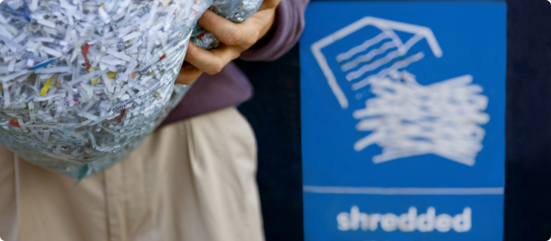 A person holding a bag of shredded paper.