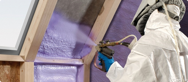 A worker spraying poly-insulation.