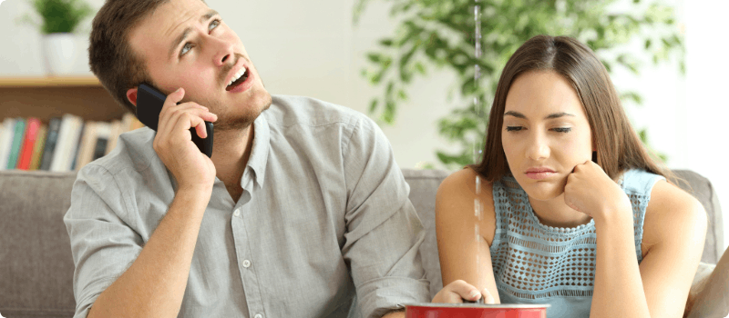 Couple sitting under a leaking roof. 