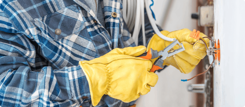 Worker fixing wires in a wall.