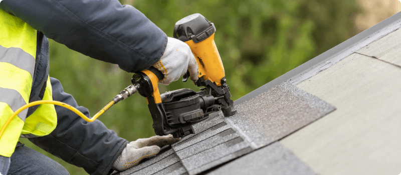 Roof being repaired by a worker.