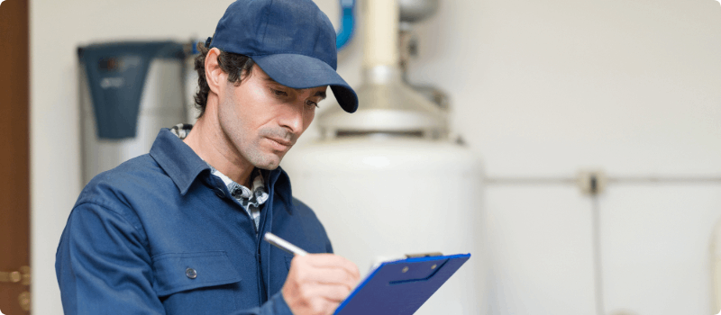 Worker holding a clipboard in a home basement.