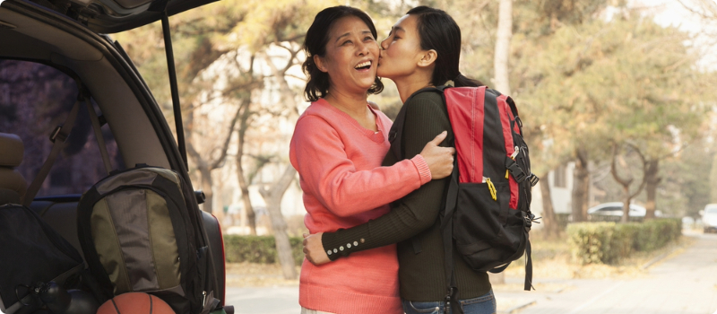 A parent embracing their child while visiting their child at university.