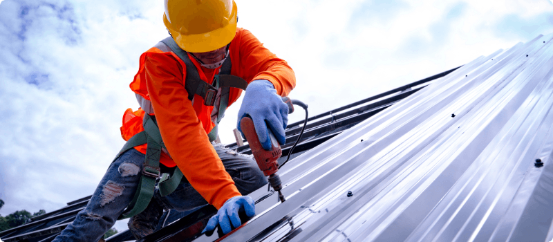 A roofer installing a metal roof.