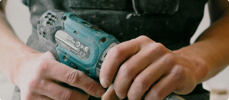 A close-up of a person holding an impact driver.