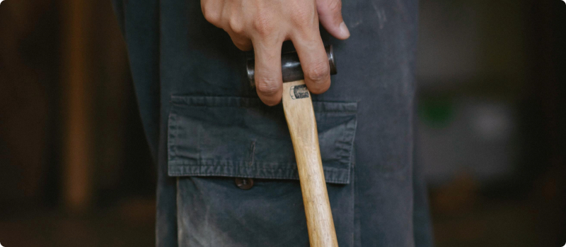 A close-up of a person holding a hammer.