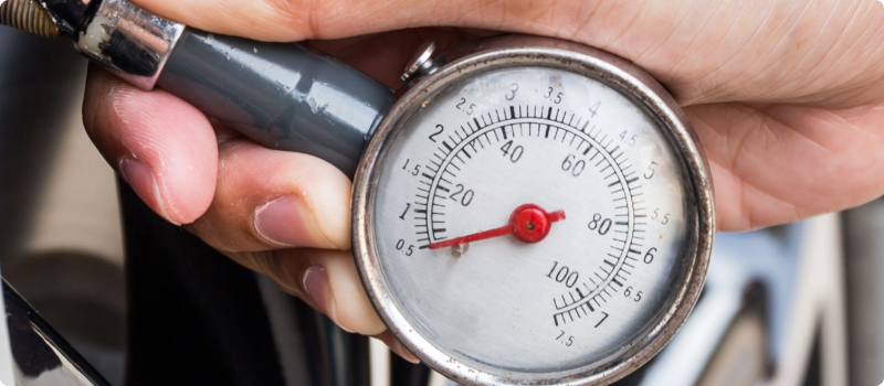 A close-up of a person checking their tire pressure.