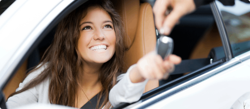 Person handing off car keys to another driver.