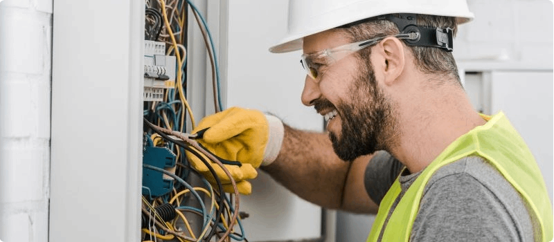 Happy construction worker fixing circuit breaker. 