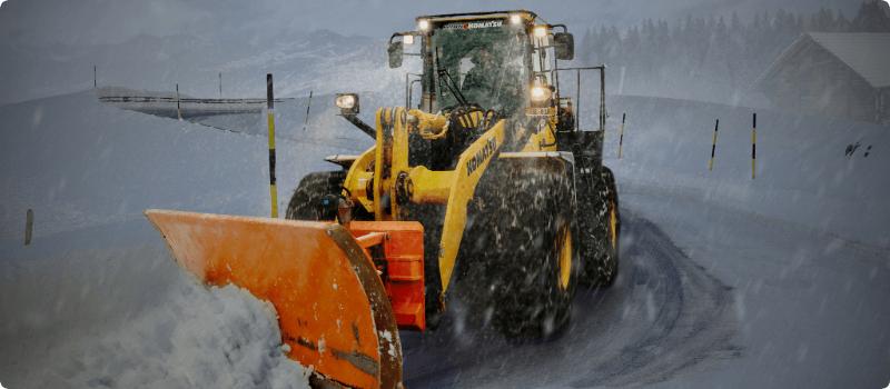 A snowplow clearing a road in a snowstorm.