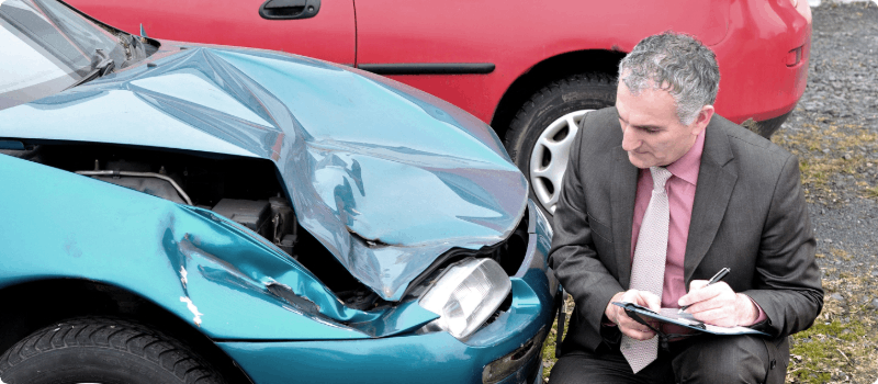 Insurance adjuster reviewing car accident damages.