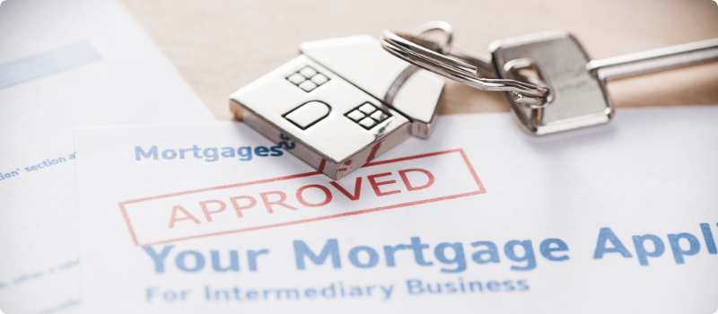 Approved mortgage application with keys to a new home. 